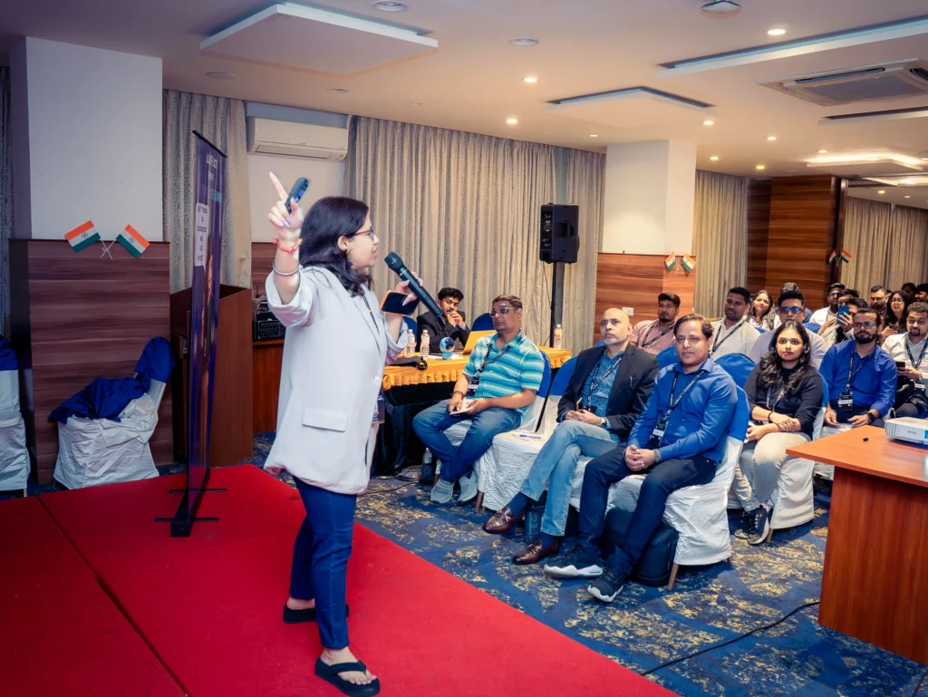 Wide view of attendees watching a keynote presentation during a leadership summit in Bengaluru.