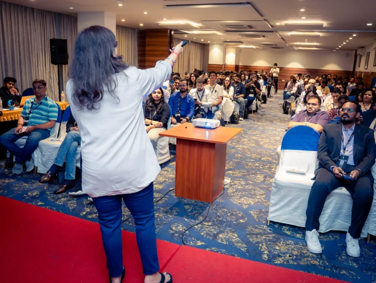 Rear view of a speaker presenting to attendees during a corporate event in Bengaluru.