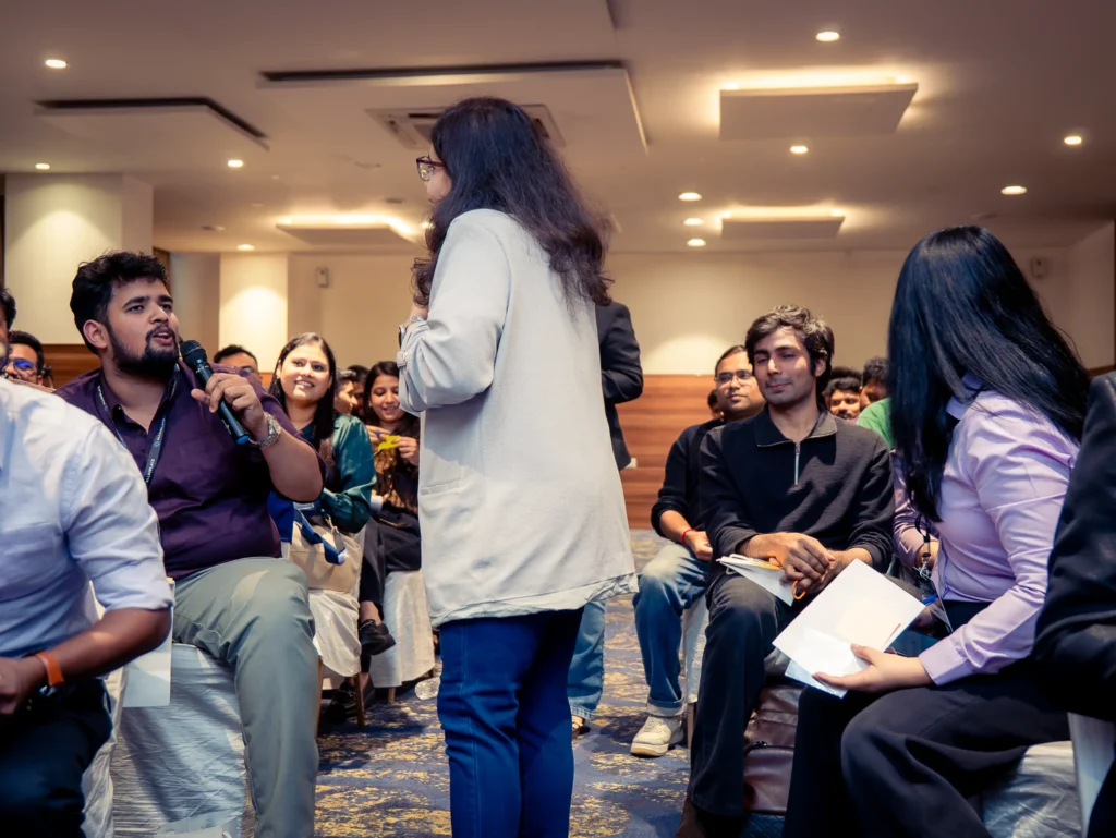 Speaker delivering a presentation during a corporate leadership summit in Bengaluru with attendees listening attentively.